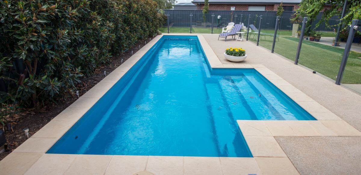 12.3m Fastlane with External Steps in colour Sapphire with semi-frameless glass fencing. Pool installed by Swan Hill Pool and Spa Centre. Compass Pools Australia 12.3m Fastlane External Steps Sapphire Swan Hill Pool and Spa