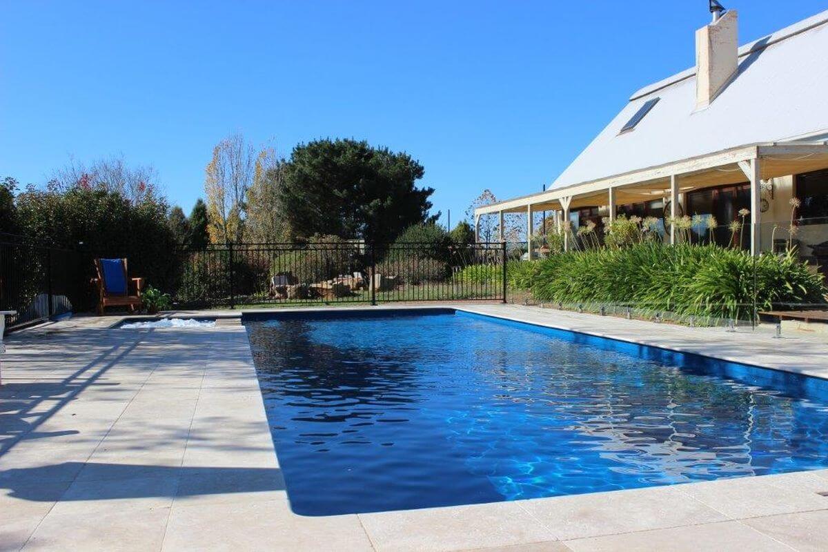 11.8m X Trainer in colour Pacific with aluminium fencing. Installed by Capital Country Pools. Compass Pools Australia X Trainer 11.8m in colour Pacific Capital Country